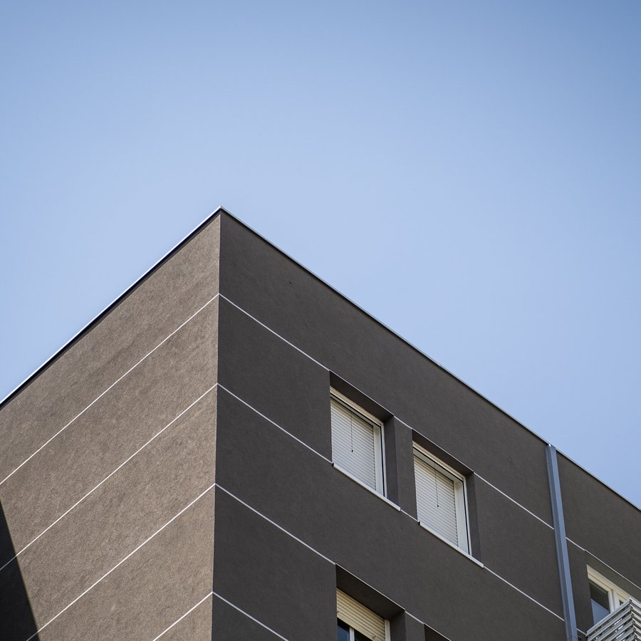 Esquina oscura del edificio recortada contra el cielo